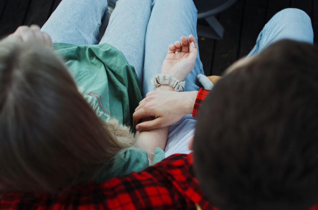 Sécurité émotionnelle dans le couple : une femme assise tenue par la main de son partenaire